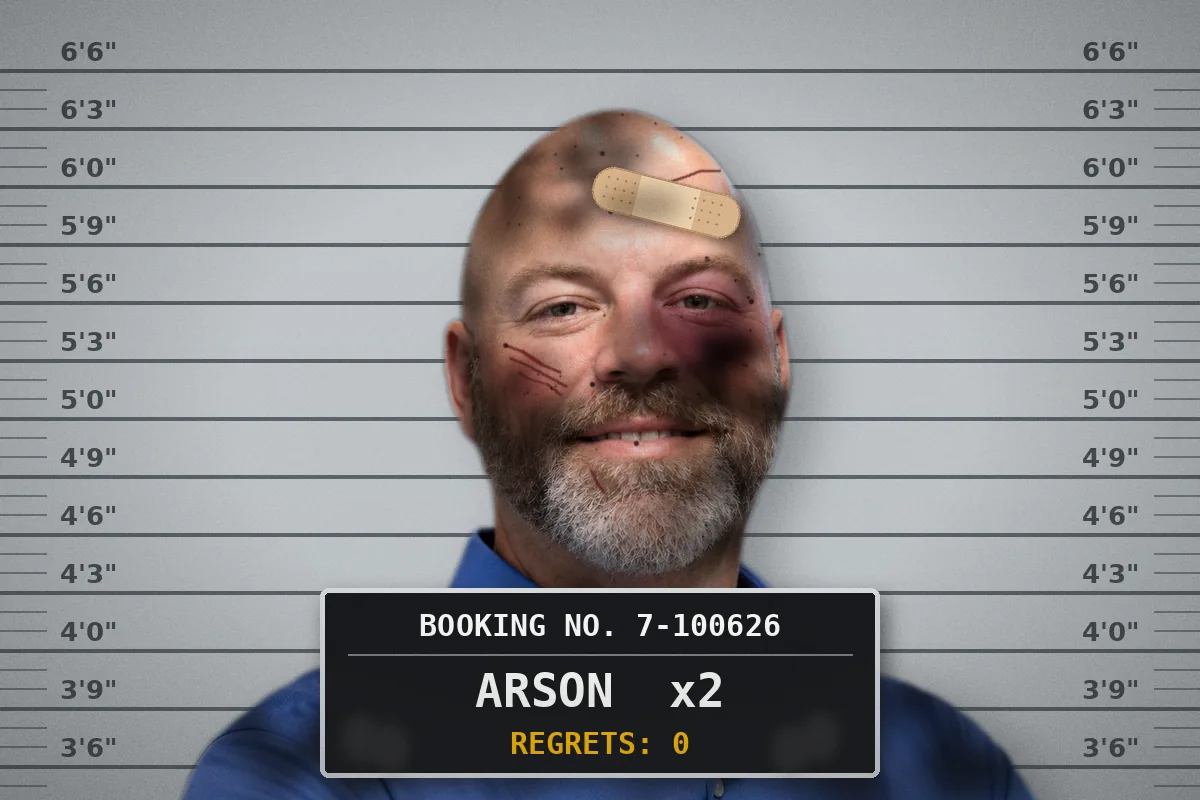 Booking photo of Chris smiling in front of a height chart, covered in soot with a black eye and a bandage on his forehead, behind a placard that reads Arson x2, Regrets: 0
